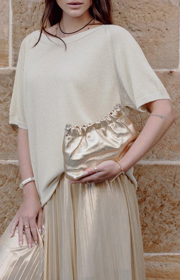 Gold metallic leather ruched crossbody bag with closure and adjustable strap – Luxe accessory Volange Paris Fashion.