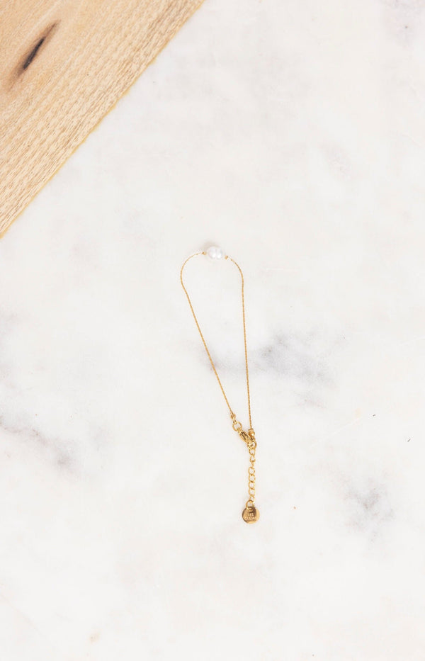 Delicate gold bracelet with a single pearl and adjustable chain – French fashion accessory by Volange Paris.