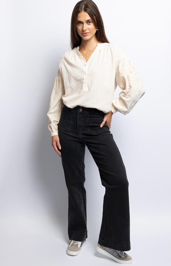 High-waisted wide-leg black jeans with front patch pockets and double-button closure – Volange Paris, French fashion.