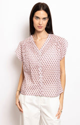 Pink printed cotton blouse with V-neckline, cap sleeves, and button-down front – French-inspired style by Volange Paris.