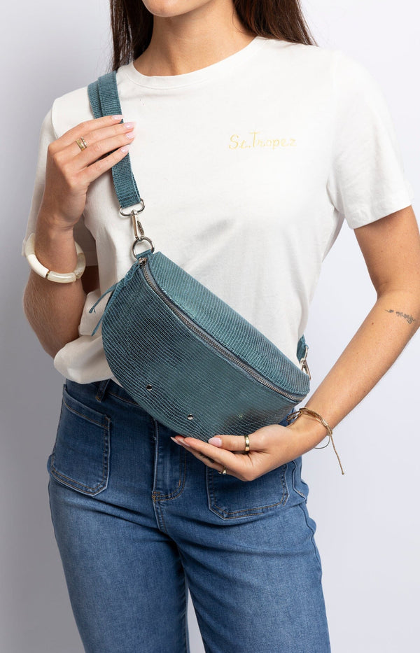 Chic teal leather belt bag with embossed texture and adjustable strap – Sophisticated French fashion accessory from Volange Paris.